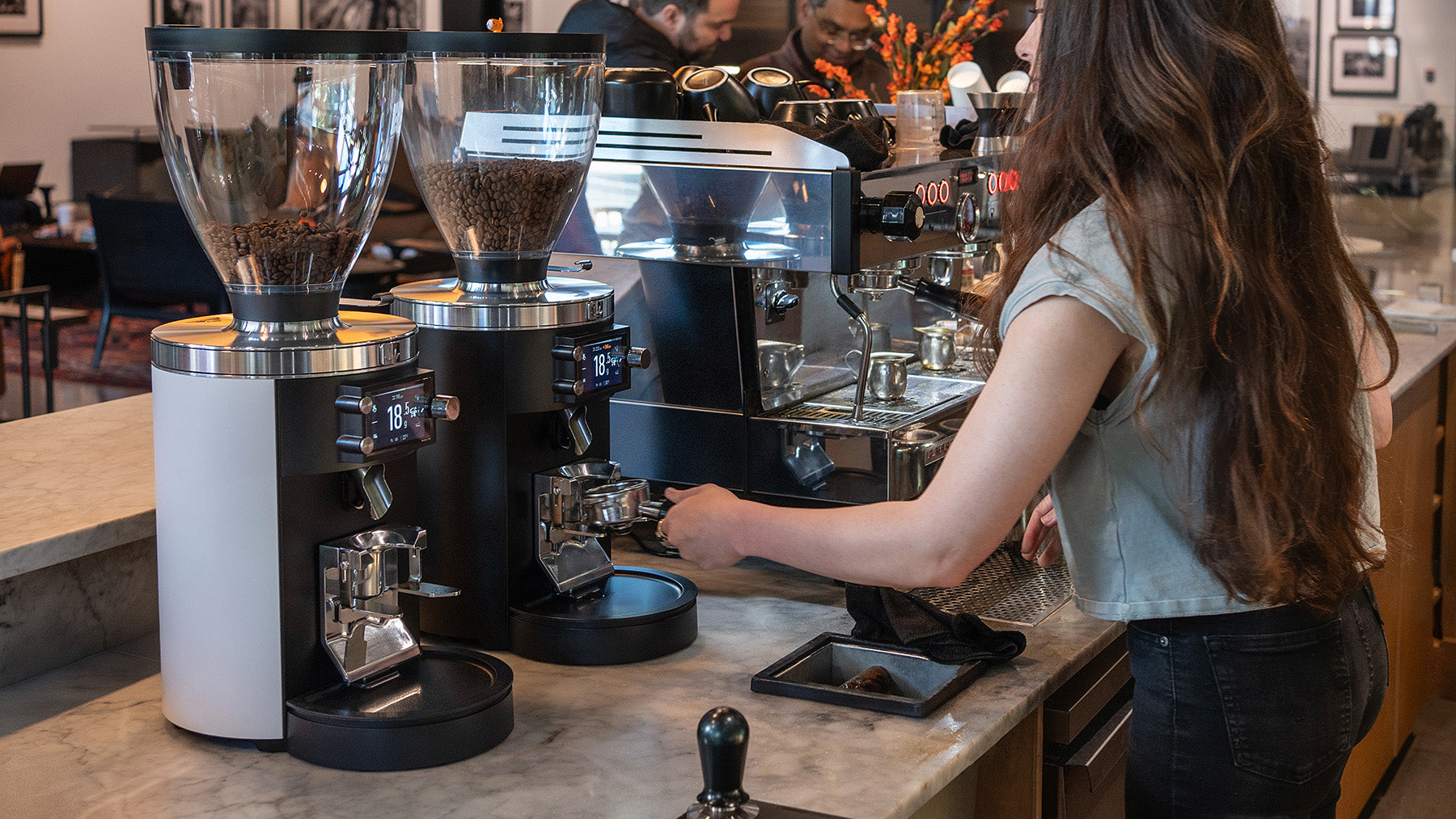 Mahlköng Grind-by-Sync grinders on cafe bar with barista
