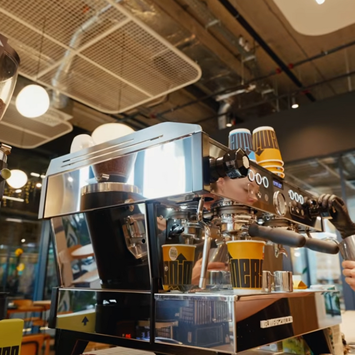 Barista using espresso machine and GbS grinder